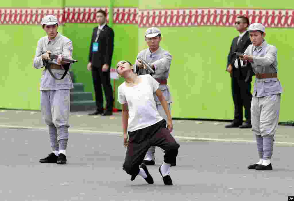 Para seniman melakukan &quot;aksi teatrikal&quot; yang menggambarkan pembantaian intelektual Taiwan oleh pasukan China daratan tahun 1947, pada upacara pelantikan Presiden Taiwan, Tsai Ing-wen di Taipei.