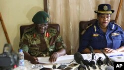 Zimbabwe army spokesperson Colonel Overson Mugwisi, left, addresses a press conference with police spokeswoman Charity Charamba, at Police General Headquarters in Harare, Zimbabwe, Nov. 27, 2017.