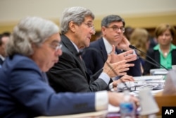 Secretary of State John Kerry, center, flanked by Treasury Secretary Jacob Lew, right, and Energy Secretary Ernest Moniz, testifies on Capitol Hill in Washington, Tuesday, July 28, 2015.