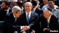 Israeli President Shimon Peres shakes hands with U.S. Secretary of State John Kerry as Prime Minister Benjamin Netanyahu sits in between them during a ceremony marking Israel's annual day of Holocaust remembrance, at Yad Vashem, Jerusalem, April 8, 2013.