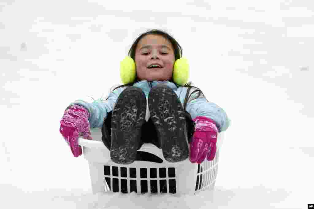 Peyton McKinney uses a clothes basket as a sled in Nolensville, Tennessee, Feb. 15, 2021.&nbsp;Many parts of Tennessee and surrounding states were hit with a winter storm that brought freezing rain, snow, sleet and extremely cold temperatures.