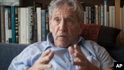 FILE - Israeli writer Amos Oz poses for a photo at his house in Tel Aviv, Israel, Nov. 4, 2015.