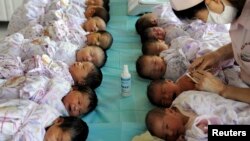 Newly born babies receive vaccines at a hospital in Aksu, Xinjiang Uighur Autonomous Region August 10, 2012. Half of China's 1.34 billion population live in cities and towns, according to a census on April 28, 2011 that pointed to the daunting tasks ahead