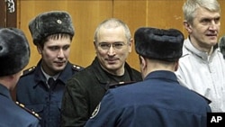 FILE - Mikhail Khodorkovsky, center, and his co-defendant Platon Lebedev, right, are escorted to a court room in Moscow on December 27, 2010.