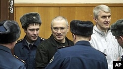 Mikhail Khodorkovsky, center, and his co-defendant Platon Lebedev, right, are escorted to a court room in Moscow, 27 Dec 2010