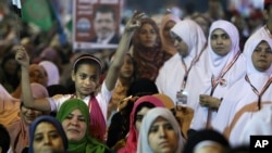 A young girl flies an Egyptian national flag as she listens to Mohammed Mursi, the Muslim Brotherhood's presidential candidate, at a rally in Cairo, May 20, 2012.