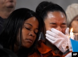 FILE - A woman cries during a candlelight vigil for shooting victims on Thursday, Dec. 3, 2015.