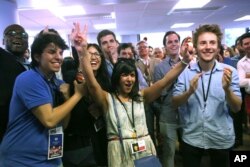 Macron's La Republique en Marche party members react after the announcement of the first partial official results and polling agencies projections are announced, in Paris, June 11, 2017.