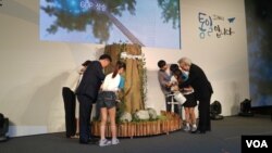 지난 23일 광화문 나인트리컨벤션에서 열린 제4회 통일교육주간 기념식에서 참석자들이 통일나무에 물을 주고 있다.