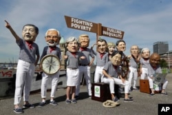 Oxfam stage a protest demanding less poverty and less inequality from the G-20 summit with figures of, from left, Chinese President Xi Jinping, Indian Prime Minister Narendra Modi, British Prime Minister Theresa May, U.S. President Donald Trump, Japanese Prime Minister Shinzo Abe, France's President Emmanuel Macron, German Chancellor Angela Merkel, Canada's Prime Minister Justin Trudeau, Russian President Vladimir Putin, Italian Prime Minister Paolo Gentiloni and South African President Jacob Zuma in Hamburg.