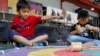 Dua orang anak laki-laki bermain gasing dalam acara permainan tradisional di sebuah sekolah di Jakarta (1/10). (Reuters/Iqro Rinaldi)