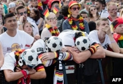 Supporters of the German national football team react as they attend a public viewing event at the Fanmeile in Berlin to watch the Russia 2018 World Cup Group F football match between South Korea and Germany on June 27, 2018.