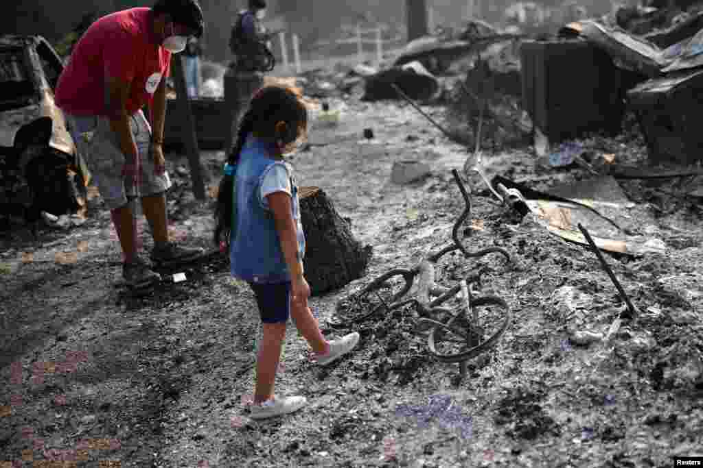 Oregon&#39;ın Phoenix kentindeki yangının ardından 3 yaşındaki Ashley yanan bisikletine bakıyor, 10 Eylül 2020.
