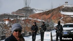 Armed police man a checkpoint at the entrance of Taktser, the village where the Dalai Lama was born.