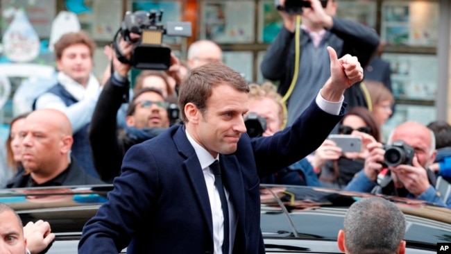 El candidato centrista Emmanuel Macron, saluda después de votar en la primera vuelta de las elecciones presidenciales francesas, en Le Touquet, en el norte de Francia, el domingo 23 de abril de 2017.