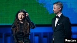 Lorde is accompanied by producer Joel Little after they won the award for Song of the Year for "Royals" at the 56th annual Grammy Awards in Los Angeles, Jan. 26, 2014.
