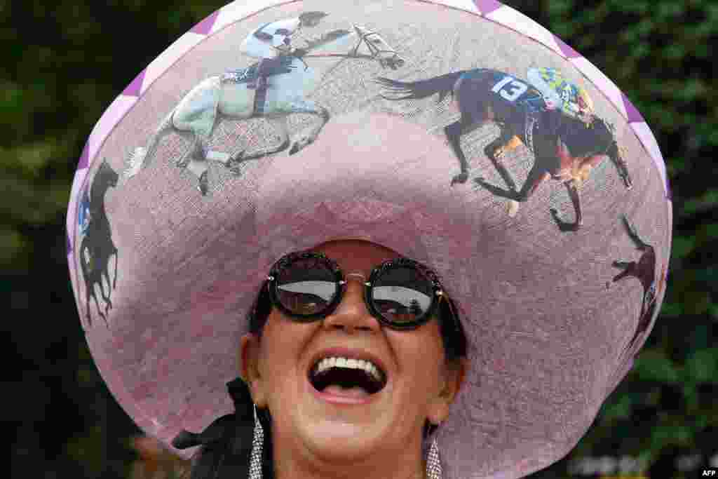 A woman poses on day one of the Royal Ascot horse racing meet, in Ascot, west of London. The five-day meeting is one of the highlights of the horse racing calendar. Horse racing has been held at the famous Berkshire course since 1711 and tradition is a hallmark of the meeting.