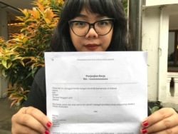 Ketua Serikat Pekerja Media dan Industri Kreatif (Sindikasi), Ellena Ekarahendy, menunjukkan contoh pedoman kontrak kerja bagi pekerja lepas. (Foto: VOA/Rio Tuasikal)