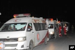 FILE - Photo released by the Syrian official news agency SANA, shows members of the Syrian Arab Red Crescent gathering near their ambulances during a human evacuation of sick and wounded people from the eastern Ghouta, near Damascus, Dec. 28, 2017.