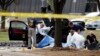ماموران پلیس فدرال آمریکا (اف بی آی) در حال بررسی جنازه مهاجمان و محل تیراندازی در اطراف نمایشگاه کاریکاتور گارلند در حومه دالاس