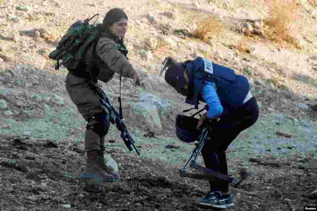 An Israeli soldier sprays pepper spray towards a journalist during a protest against Israeli settlements, near Tubas in the Israeli-occupied West Bank, July 27, 2021.