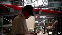 Seorang pengunjung menaiki eskalator di salah satu pusat perbelanjaan di Beijing, China, pada 19 Juli 2018. AS beserta sekutunya mengecam kebijakan perdagangan yang diterapkan oleh pemerintah China dalam sebuah forum WTO baru-baru ini. (Foto: AP/Mark Schiefelbein)