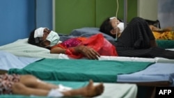 Injured Myanmar refugees rest after receiving medical attention at Sop Moei Hospital in Mae Hong Son province on March 30, 2021, after crossing into Thailand via the Salween river following air strikes in Myanmar's Karen state. (Photo by Lillian SUWANRUMP