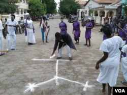 FILE - A man draws a vèvè symbol – common in voodoo, a religion known in Haiti as Vodou – during a celebration of Fèt Gede in the northeast Haitian city of Fort-Liberte, Nov. 1, 2017. (Jaudelet Junior Saint Vil/VOA)