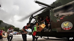 Volunteers carry relief materials to an Indian air force helicopter to airdrop in quake-hit remote villages in Mangan, India, September 22, 2011.