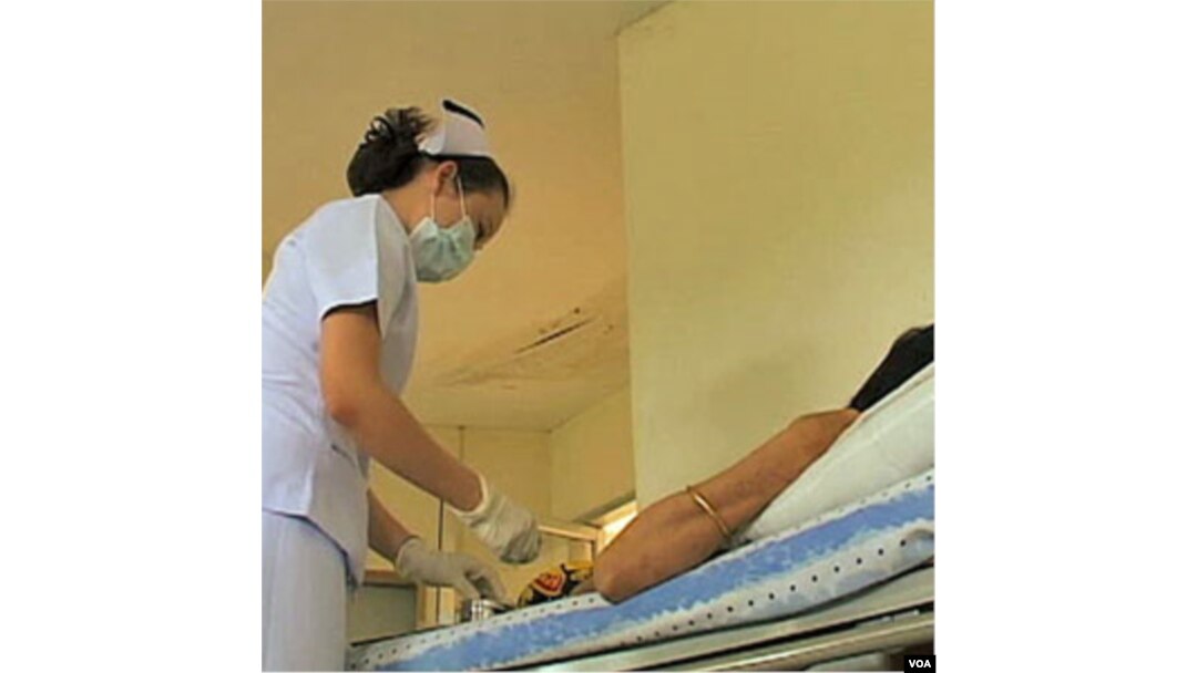 Seorang perawat di Thailand memberika obat anti-retrovirus kepada seorang pasien HIV.
