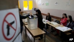 A woman votes at a polling station in the northern Serb-dominated part of Mitrovica, Kosovo, Nov 3, 2013.