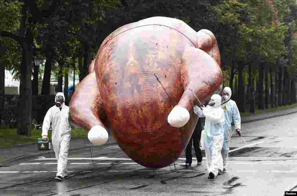 Environmental activists carry a giant inflatable chicken as they demonstrate against 'chlorine chickens' near the Oktoberfest grounds in Munich, Germany. The protest is against the planned Free Trade Agreements TTIP (Transatlantic Trade and Investment Partnership) and CETA (Comprehensive Economic and Trade Agreement) with the U.S. and Canada, which opponents fear will allow U.S. chlorine-washed chicken and hormone treated meat into the EU.