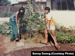 Sonny Duong and his sister, Co Tong with plants in their garden in California with seeds their father brought from Vietnam.