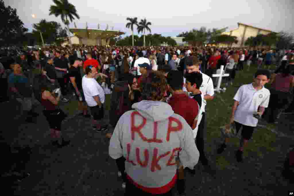 Zachary Haupert, 14, painted "RIP Luke," on his hoodie in honor of his friend Luke Hoyer, who was one of the victims of the shooting at Marjory Stoneman Douglas High School, as he attends a candlelight vigil, Feb. 15, 2018, in Parkland, Florida. 