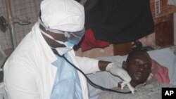 A health worker examines a man suffering from Ebola at a treatment centre in Monrovia, Liberia, Wednesday, Oct. 15, 2014. 