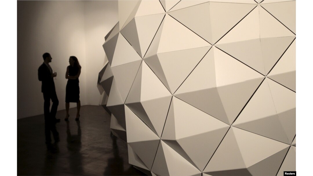 Visitors stand around the showcase piece by Iranian sculptor Sahand Hesamiyan at the Third Line Gallery in Dubai, Nov. 19, 2014.