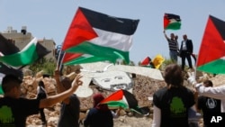 Para aktivis Palestina berdema dekat instalasi militer Israel di Kota Ramallah, Tepi Barat, 9 Mei 2017.