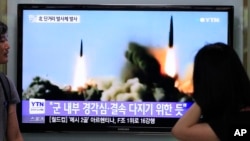 South Koreans watch a TV news program showing the missile launch conducted by North Korea, at Seoul Railway Station, Seoul, June 26, 2014.