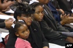 The wife of South Carolina State Sen. and Rev. Clementa Pinckney, Jennifer, sits with daughters Malana and Eliana (R) during his funeral, at the College of Charleston TD Arena, June 26, 2015.