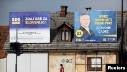 A woman walks under election posters of the Slovenian Democratic Party ahead of elections in Ljubljana, Slovenia, May 31, 2018. 