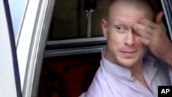 FILE - In this file image taken from video obtained from Voice Of Jihad Website, which has been authenticated based on its contents and other AP reporting, Sgt. Bowe Bergdahl, sits in a vehicle guarded by the Taliban in eastern Afghanistan.