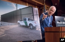 FILE - Senate Majority Whip John Cornyn of Texas points to a poster as he talks to reporters about border security on Capitol Hill, Washington, Aug. 3, 2017.