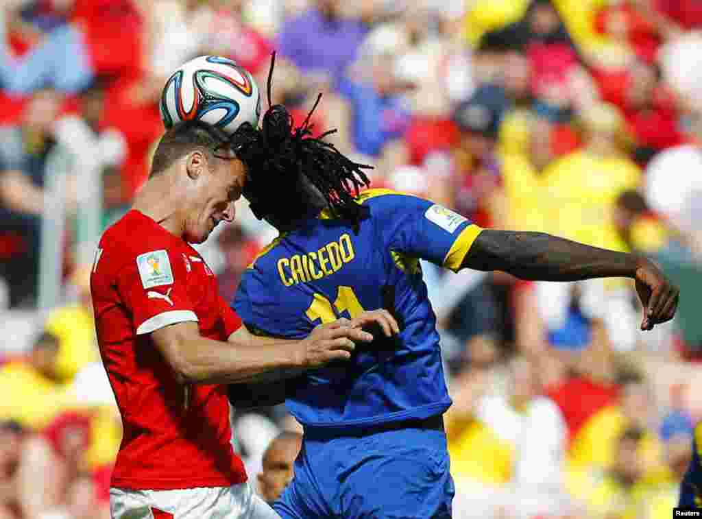 Switzerland's Steve von Bergen fights for the ball with Ecuador's Felipe Caicedo (R) during their 2014 World Cup Group E soccer match at the Brasilia national stadium in Brasilia, Brazil.