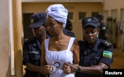 Diane Shima Rwigara, a prominent critic of Rwanda's president Paul Kagame, is escorted by police officers into a courtroom in Kigali, Rwanda, Oct. 11, 2017.