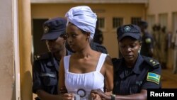 FILE - Diane Rwigara, a prominent critic of Rwanda's president Paul Kagame, is escorted by police officers into a courtroom in Kigali, Rwanda, Oct. 11, 2017.