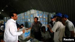 Afghan election workers count ballot papers during an audit of the presidential run-off in Kabul, Aug. 3, 2014.