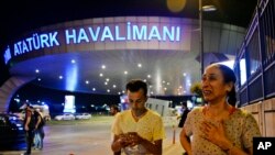 People gather at the entrance to Istanbul's Ataturk airport in the early-morning hours of June 29, 2016, after suicide bombers struck in the terminal, killing dozens of people and wounding many others.