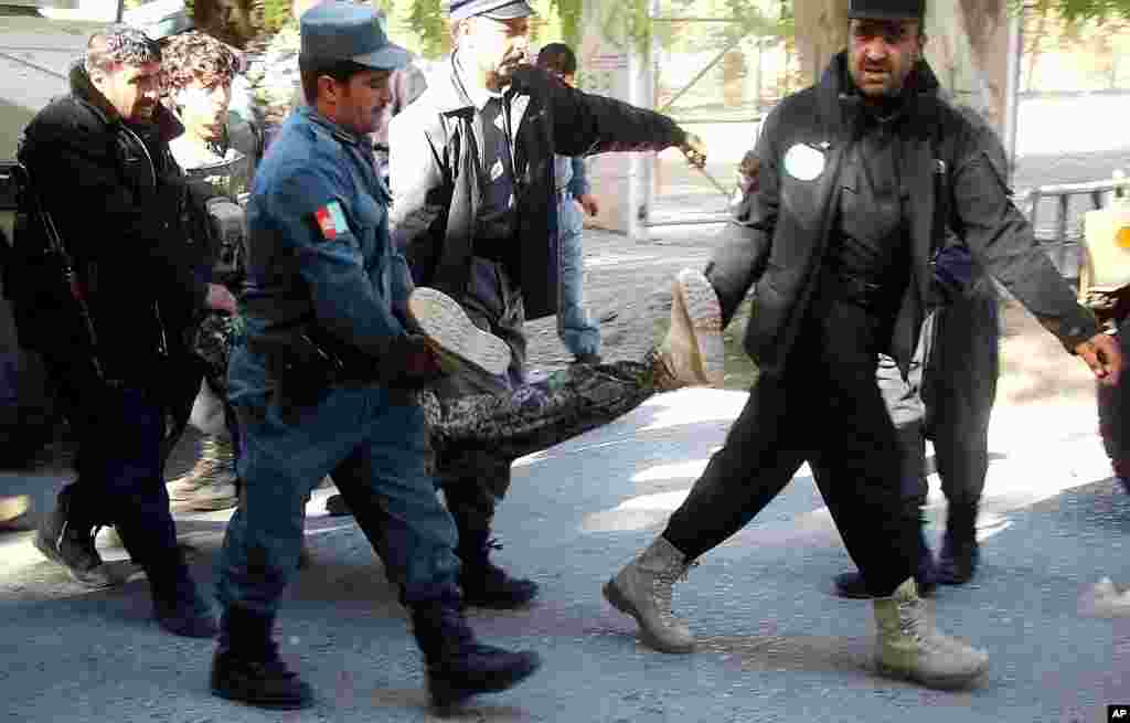 Afghanistan&#39;s security forces carry a the body of a soldier killed during clashes between Afghanistan&#39;s forces and insurgents over a branch of Kabul Bank in Lashkar Gah, capital of Helmand province, Afghanistan, Dec. 17, 2014.