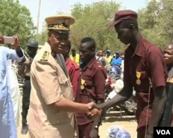 The Governor of Cameroon's far north region Midjiyawa Bakari greets a vigilante member. (M.E. Kindzeka/ VOA)