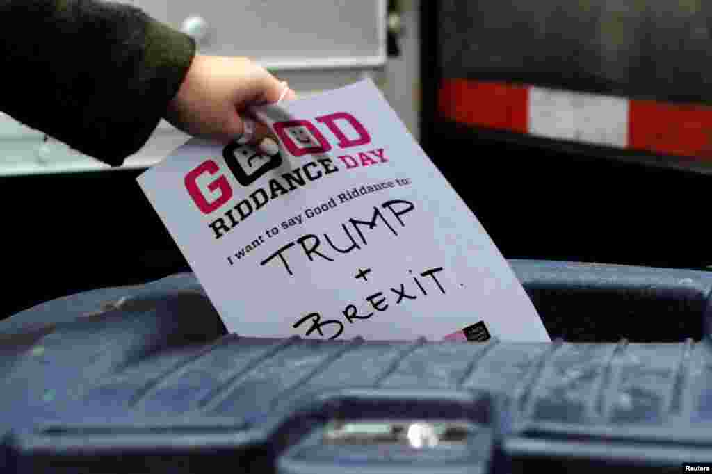 A participant throws a piece of paper reading "Trump and Brexit" into a trash can to be shredded during "Good Riddance Day" in Times Square, New York City, Dec. 28, 2016.